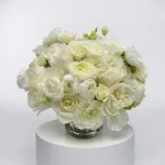 Manhattan Blanc premium white flower arrangement featuring roses, ranunculus and lisianthus in a glass vase