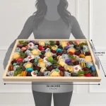 Person holding an extra-large 30 by 18 inch Christmas sweets gift tray showing its oversized dimensions
